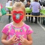 Bild - Kind mit bemaltem Gesicht und selber gebastelter Halskette