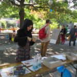 Bild - Frau mit Kopftuch bastelt am Stand des Familienzentrum