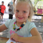 Bild - Mädchen mit selbst gebastelter Halskette