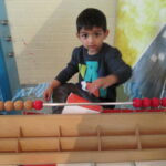 Bild: Junge lernt an einem Abakus (Rechenhilfsmittel mit Kugeln)