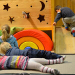 Bild: Kinder spielen auf der Krabbelburg, davor leigen zwei Kinder auf dem Fußboden