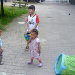 Bild: 2 Kleinkinder und ein Junge mit Boule-Kugeln auf der Strasse