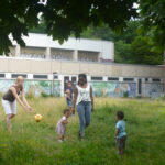 Bild: Mütter mit Kindern spielen gemeinsam auf einer Wiese