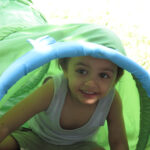 Bild: Junge gickt aus einem Klettertunnel