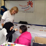 Bild: Am Stand vom Familienzentrum. Einem Kind wird das Gesicht bemalt.