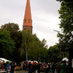 Bild: Leute auf der Strasse, Kiche im Hintergrund