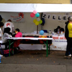 Bild: Der Stand vom Familienzentrum. Im Vordergrund stehen Besucher.