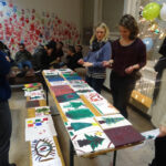 Viele tolle Weihnachtsbaumbilder. | © FZM Bild: die Leiterin und das Team betrachten die gemalten Weihnachtsbaumbilder der Kinder auf einem Tisch