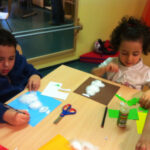 Bild: Kinder sitzen basteln am Tisch