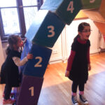 Bild: zwei Kinder spielen an einem aus großen Bauklötzern zusammangesetzten Torbogen