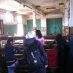 Ausflug zur Domäne Dahlem | © FZM Bild: Besucher stehen am Stallzaun und schauen den Ziegen beim Fressen zu