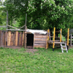 Bild: eine Holzhütte auf einer Wiese