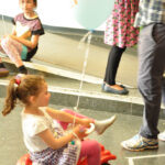 Bild: Kind mit Luftballon auf Spielzeugauto