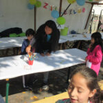 Bild: Mutter malt mit ihren Kindern auf einem Tisch am Stand des Familienzentrums Moabit-Ost