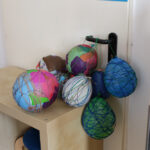 Foto: Luftballons mit Schnur oder buntem Papier ummantet hängen an einer Türklinke