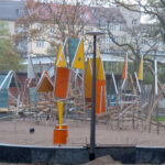 Bild: Holzstangen, Stahlrohr und bunte Flächen miteinander verschraubt zu einem großen Klettergerüst auf eine großen Sandfläche