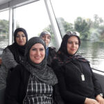 Foto: 4 Frauen mit Kopftuch sitzen in einem Motorschiff mit Blick in die Kamera. Fensterim Hintergrund.