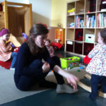 Foto: Frau spielt mit Kind am Schaukelpferd