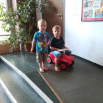 Foto: zwei Kinder auf einer Rampe, das rechte Kind sitzt auf einem Bobby Car