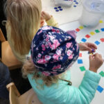 Die Kinder konnten Perlen-Armbänder basteln | Foto: © FZM Foto: zwei Mädchen von oben fotografiert, die Perlen auffädeln