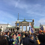 Foto: große Menschenmenge demonstriert vor dem Brandenburger Tor in Berlin