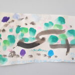 Foto: Blatt Papier mit bunten Farbtupfern und braunen Linien bemalt, Schriftzug Osterschatzkarte für Kurt