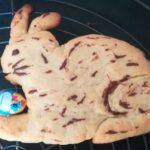 Ein leckerer Osterhase | Foto: © FZM Foto: Ein gebackener Hase mit einem Schockei zwischen den Pfoten liegt auf einem Backrost