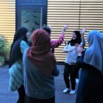 Foto: Vier Frauen stehen draußen, zwei davon haben eine Hand erhoben