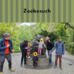 Ein Bild von der Väterrunde im Zoo. 4 Väter mit 3 Kindern (zensiert) vor einer Affenstatue