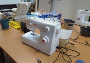 Foto: 2 Nähmaschinen und diverse andere Utensilien zum Nähen auf einem Tisch